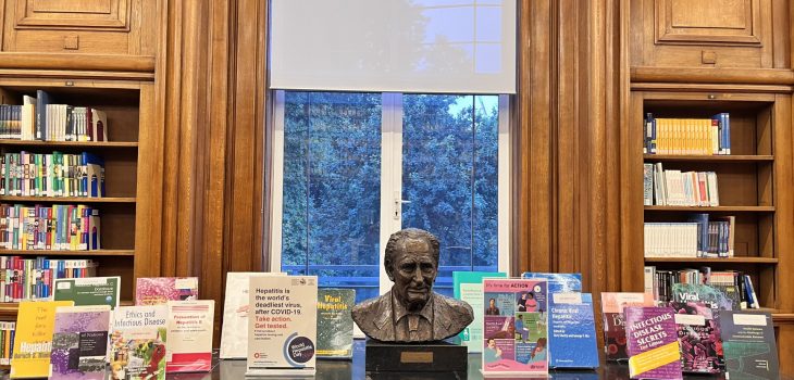 Photo of the library book display on World Hepatitis Day 2024. The photo shows the books selection from the library collections displayed in the Reading Room on the black table alongside the bust of Richard Doll.