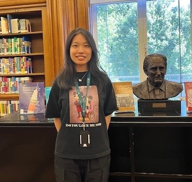 Yiyun Chen, UCL Placement Student standing in the Library next to the bust of Richard Doll